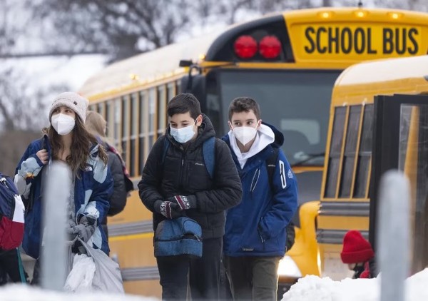 Os alunos chegam a uma escola primária em Mississauga, Ontário, depois que as escolas reabriram em janeiro do ano passado.  (foto = The Canadian Press)